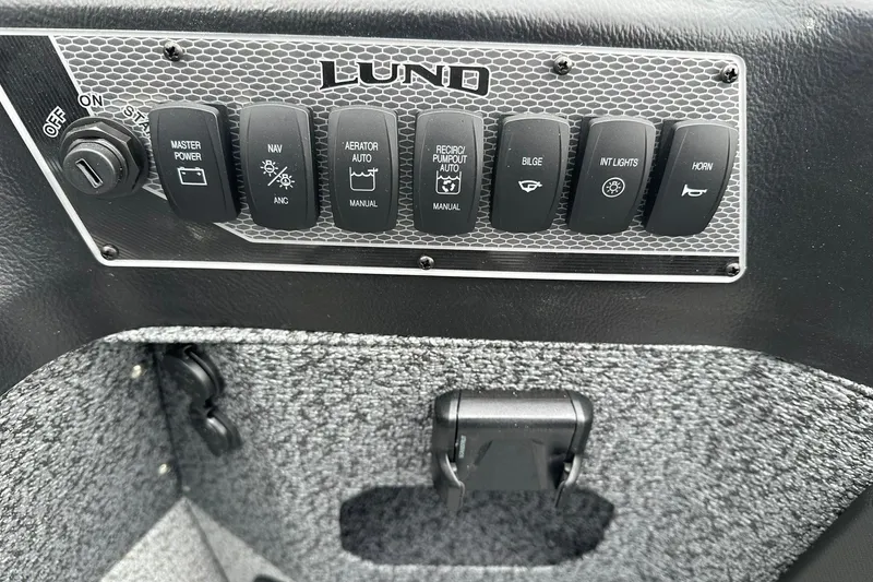 Slide: The Image of Control panel of 2026 Lund 1875 Impact XS SS boat with various switches. - 16