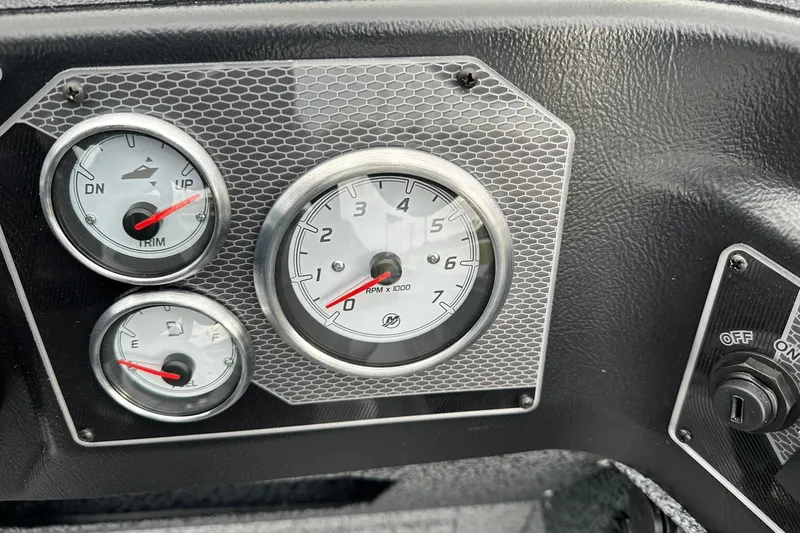 Slide: The Image of Dashboard gauges of 2026 Lund 1875 Impact XS SS boat, featuring RPM, trim, and fuel indicators. - 17