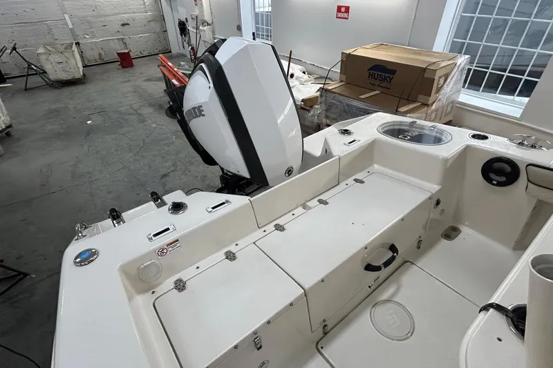 Slide: The Image of 2020 Sea Chaser 22 HFC boat interior with Evinrude engine in a warehouse setting. - 12