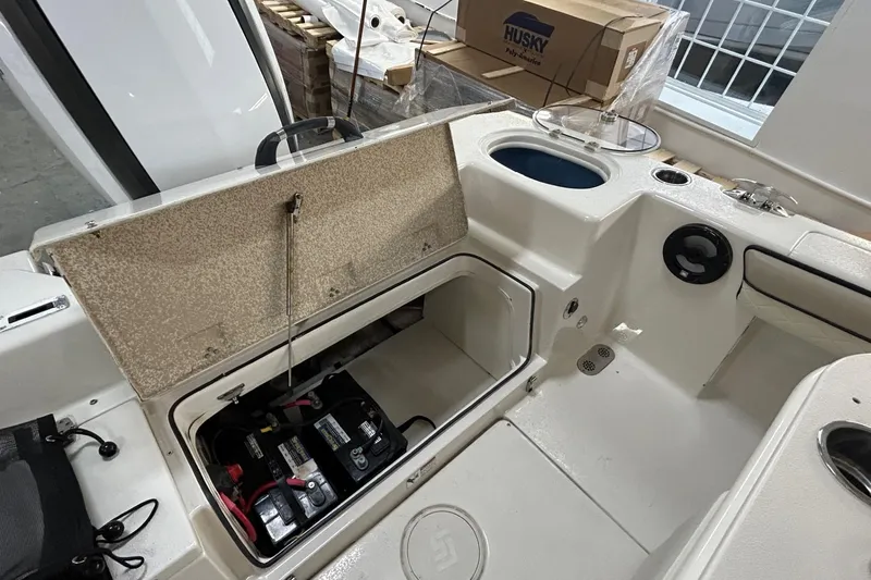 Slide: The Image of 2020 Sea Chaser 22 HFC boat interior with open storage compartment and visible battery. - 13