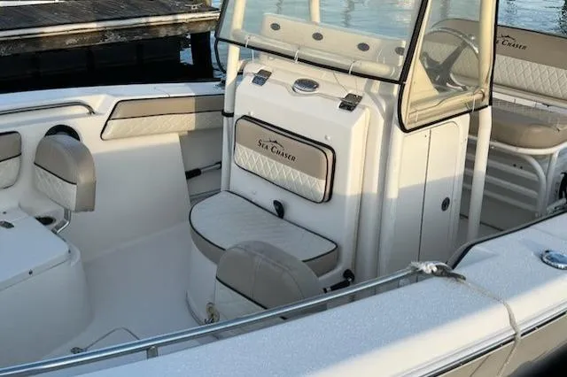 Slide: The Image of 2020 Sea Chaser 22 HFC boat interior with seating and console, docked by the water. - 7