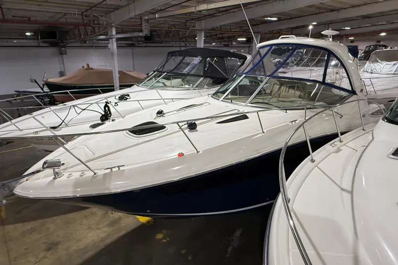 Slide: The Image of 2017 Sea Ray Sundancer 330 yacht in a showroom, surrounded by other boats. - 11