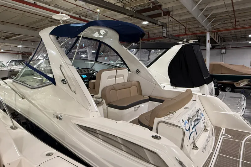 Slide: The Image of 2017 Sea Ray Sundancer 330 boat interior with brown flooring and stainless steel accents. - 16