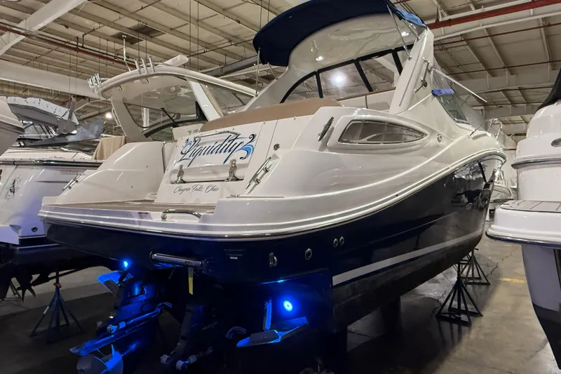 Slide: The Image of 2017 Sea Ray Sundancer 330 yacht in a showroom, featuring sleek design and blue accent lighting. - 3