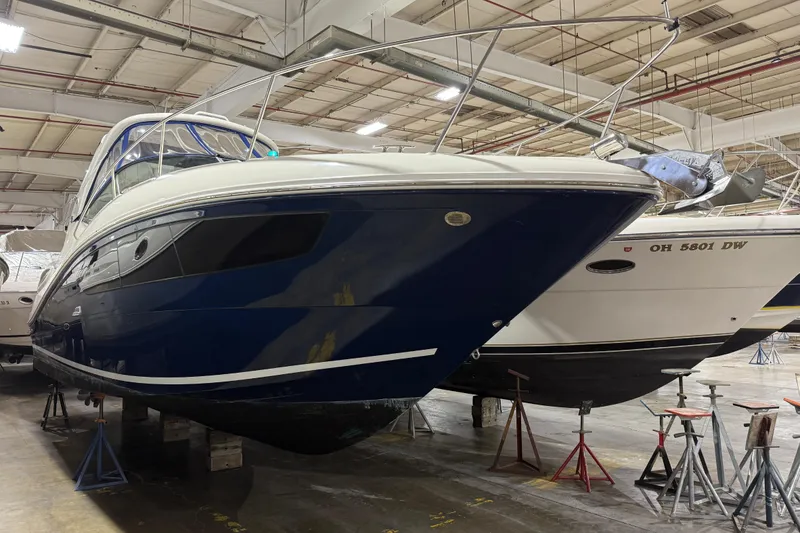 Slide: The Image of 2017 Sea Ray Sundancer 330 boat in indoor storage, blue hull, sleek design. - 6
