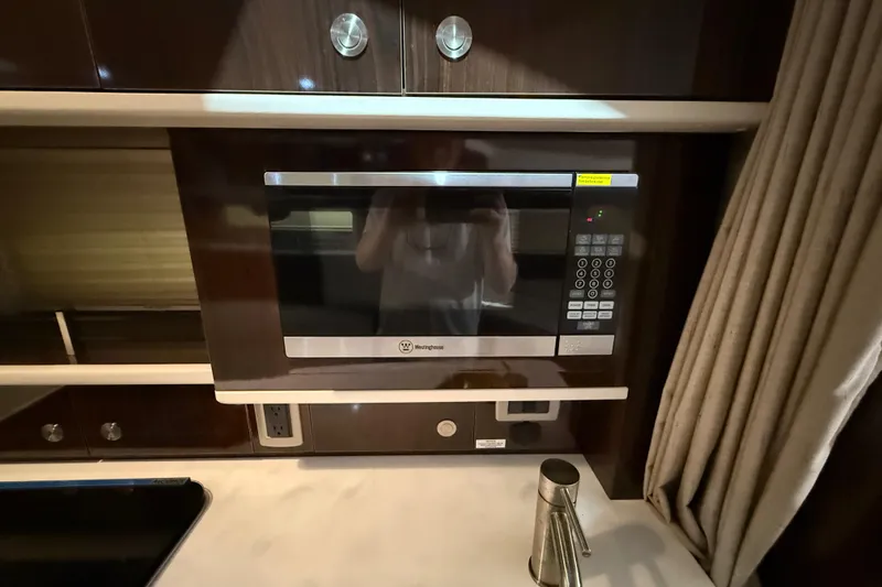 Slide: The Image of Interior of 2017 Sea Ray Sundancer 330 with beige seating and wall-mounted TV. - 60