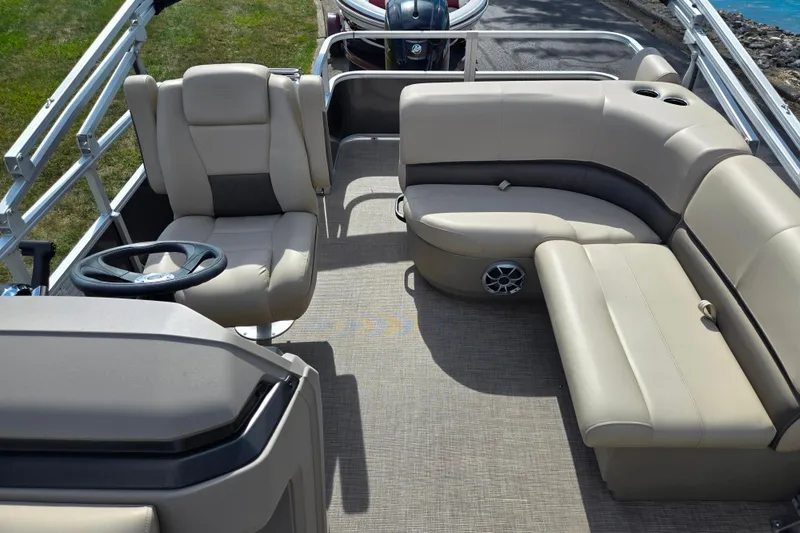 Slide: The Image of 2024 Sun Tracker Party Barge 18 DLX interior with beige seating and steering console. - 13