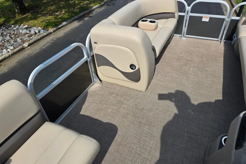 Slide: The Image of 2024 Sun Tracker Party Barge 18 DLX interior with beige seating and cup holders. - 19