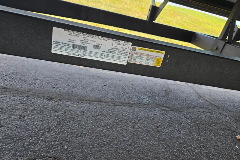 Slide: The Image of 2024 Sun Tracker Party Barge 18 DLX trailer label on asphalt surface. - 8