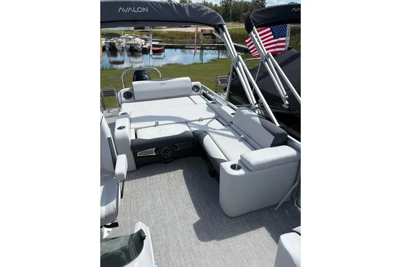 Slide: The Image of 2025 Avalon LSZ Entertainer pontoon boat with luxurious seating and American flag. - 5