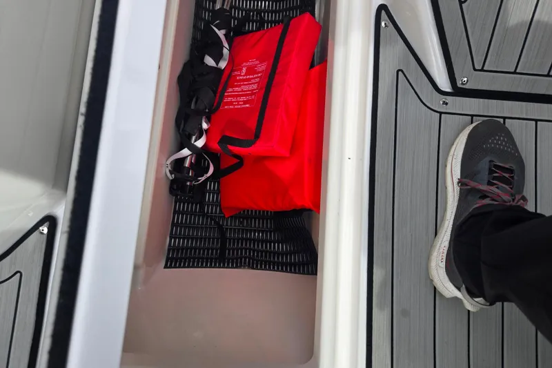 Slide: The Image of 2021 Yamaha Boats 252S interior with red life jacket and black shoe on deck. - 14