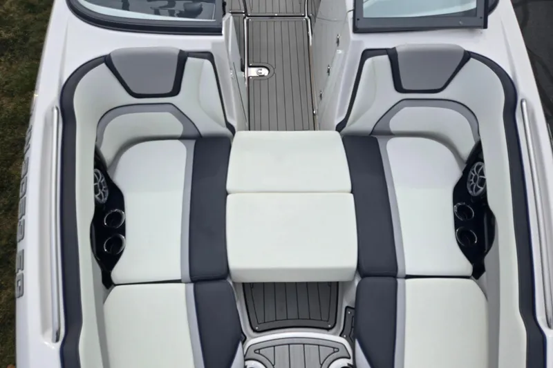 Slide: The Image of 2021 Yamaha Boats 252S interior seating with gray and white upholstery, cup holders, and speakers. - 19