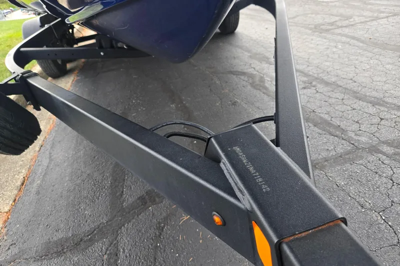 Slide: The Image of Trailer for 2021 Yamaha Boats 252S on asphalt, showcasing sturdy frame design. - 7