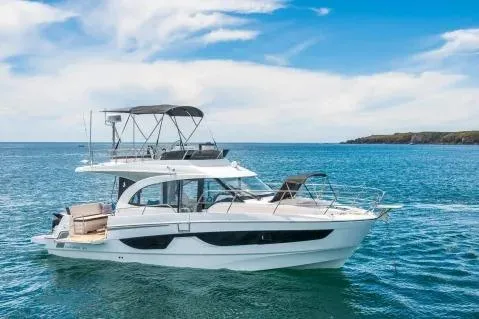 Slide: The Image of 2026 Beneteau Antares 11 Fly yacht cruising on open water under a clear blue sky. - 15