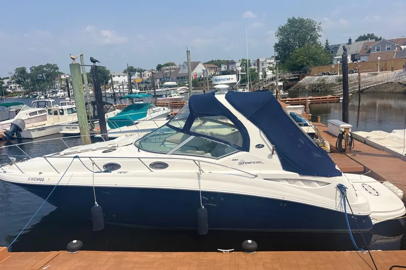 The Image of 2006 Sea Ray 320 Sundancer docked at a marina with blue canopy. - 0