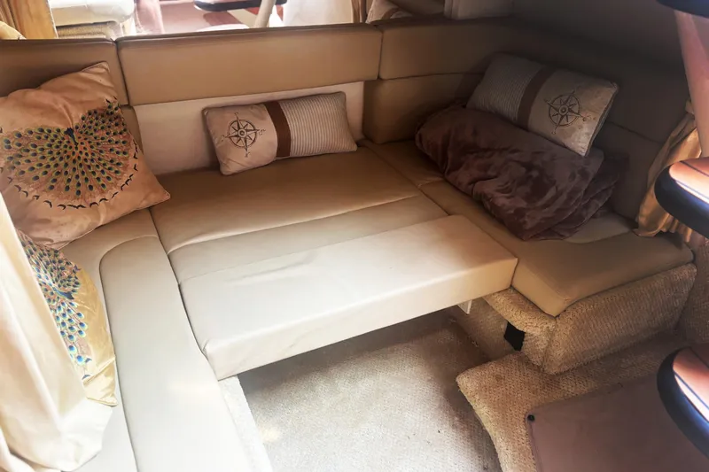 Slide: The Image of Luxurious interior of 2006 Sea Ray 320 Sundancer with beige seating and decorative pillows. - 9