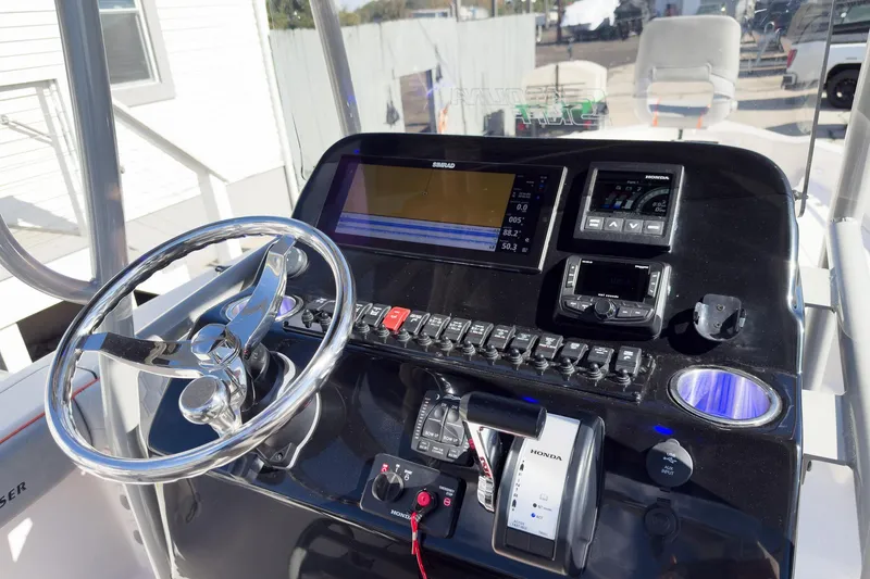 Slide: The Image of 2026 Sea Chaser 26 LX Special Edition boat displayed indoors with powerful engine. - 7