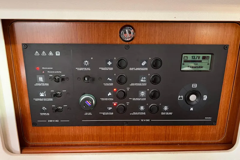 Slide: The Image of Control panel of a 2012 Beneteau Oceanis 45 yacht, featuring various switches and a digital display. - 18