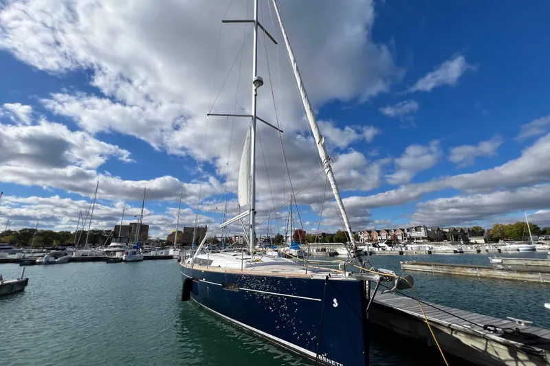 Slide: The Image of 2012 Beneteau Oceanis 45 sailboat docked in a marina under a partly cloudy sky. - 2