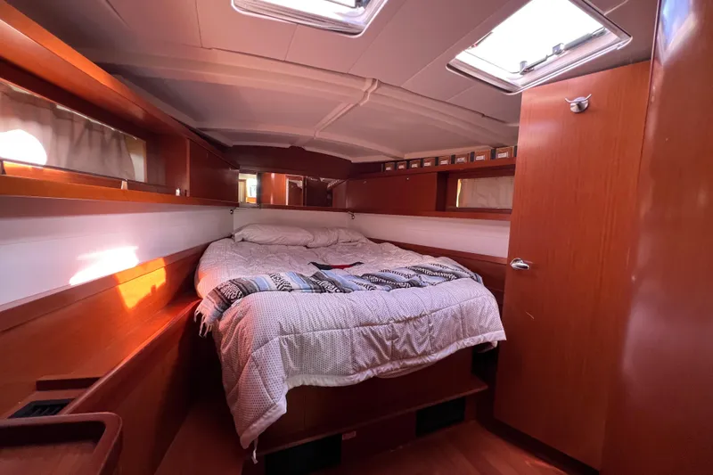 Slide: The Image of Cozy cabin interior of 2012 Beneteau Oceanis 45 sailboat with bed and wooden finish. - 24