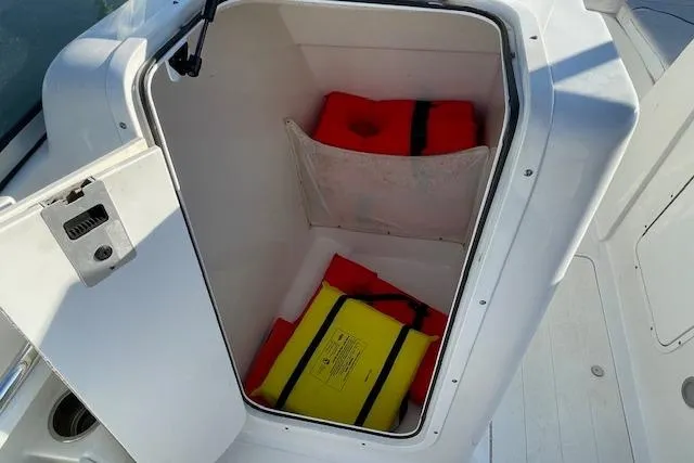 Slide: The Image of Open storage compartment on 2014 Sea Hunt Escape 235 SE with life jackets inside. - 13