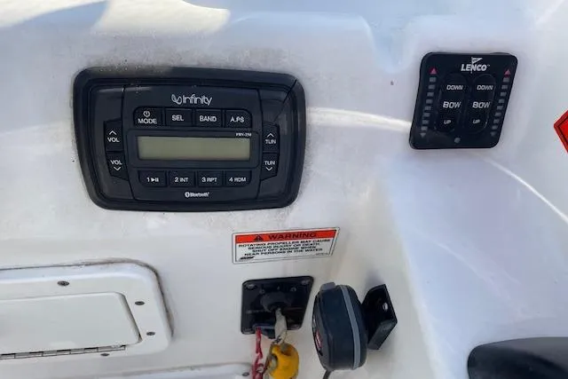 Slide: The Image of Control panel of a 2014 Sea Hunt Escape 235 SE boat with audio and trim controls. - 16