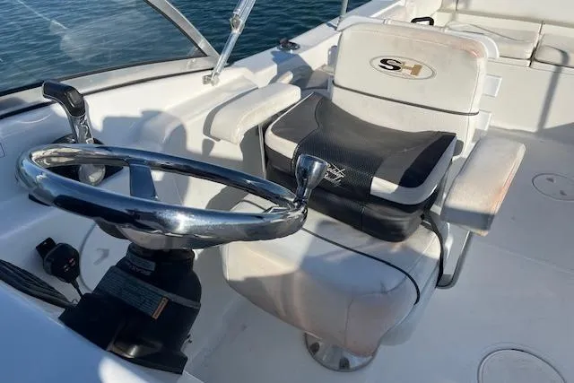 Slide: The Image of 2014 Sea Hunt Escape 235 SE boat cockpit with steering wheel and seating. - 19
