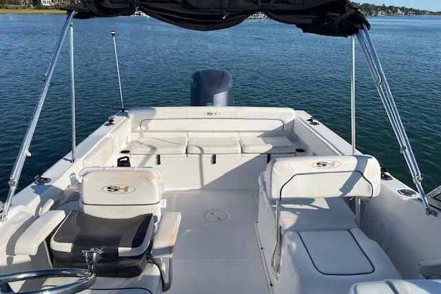 Slide: The Image of 2014 Sea Hunt Escape 235 SE boat interior with seating and canopy on water. - 21
