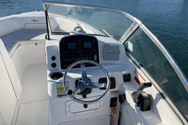 Slide: The Image of 2014 Sea Hunt Escape 235 SE boat dashboard with steering wheel and controls. - 23