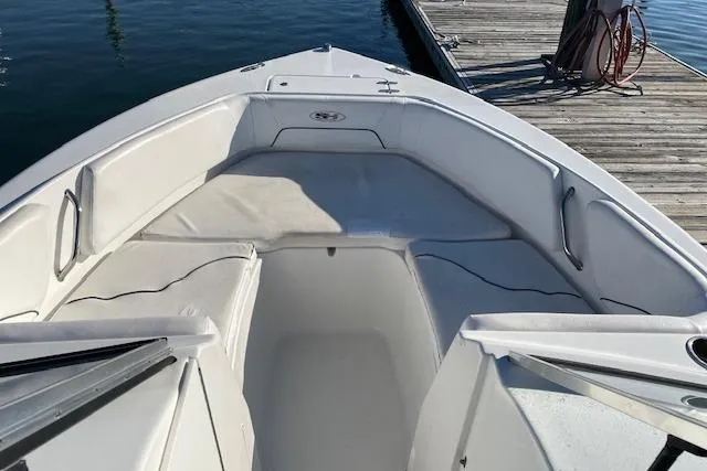 Slide: The Image of 2014 Sea Hunt Escape 235 SE boat interior with cushioned seating near dock. - 9