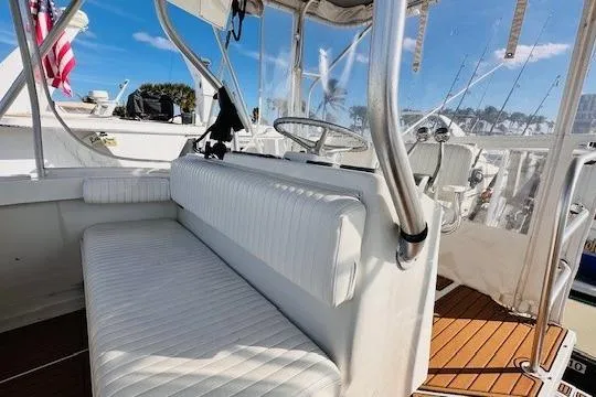 Slide: The Image of 2001 Luhrs 40 Convertible boat interior with cushioned seating and wooden deck. - 12
