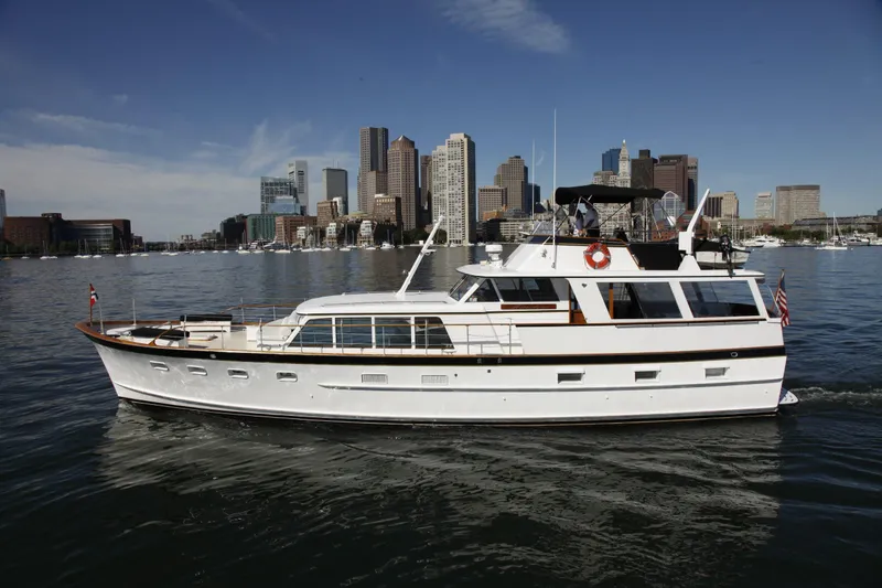The Image of 1968 Burger Motor Yacht cruising near city skyline on a sunny day. - 0