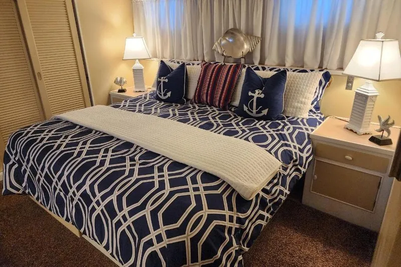 Slide: The Image of Cozy bedroom in a 1968 Burger Motor Yacht with nautical-themed decor and ambient lighting. - 18