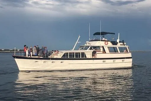 Slide: The Image of 1968 Burger Motor Yacht cruising on calm waters under a cloudy sky. - 2