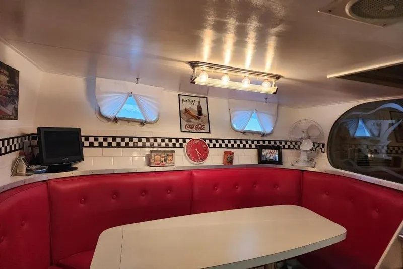 Slide: The Image of Retro diner-style interior of a 1968 Burger Motor Yacht with red seating and vintage decor. - 22