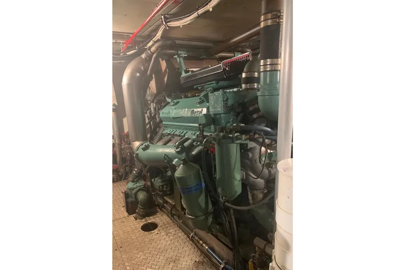 Slide: The Image of Engine room of a 1968 Burger Motor Yacht, showcasing a large diesel engine. - 26