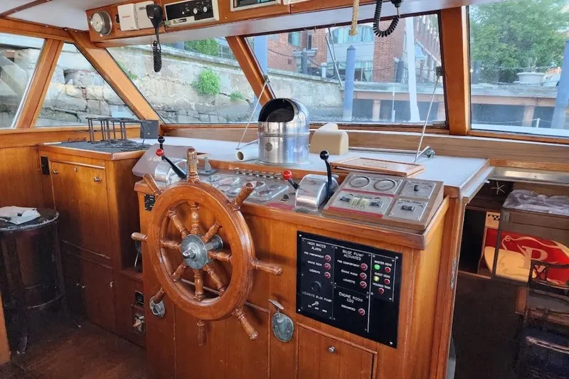 Slide: The Image of Vintage 1968 Burger Motor Yacht helm with wooden steering wheel and classic navigation controls. - 5
