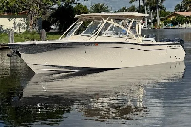 The Image of 2021 Grady-White Freedom 307 boat on calm water, surrounded by lush greenery. - 1