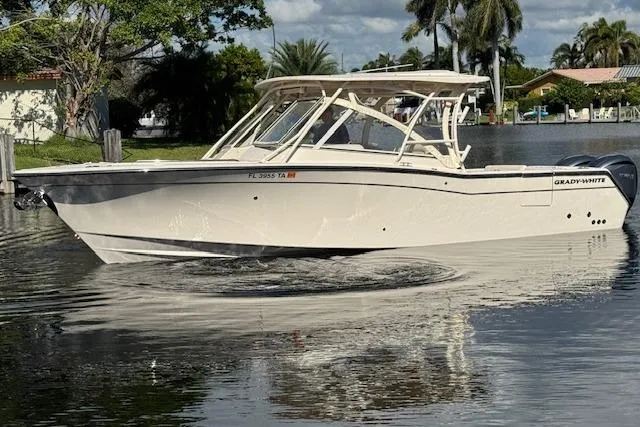Slide: The Image of 2021 Grady-White Freedom 307 boat on calm water, surrounded by lush greenery. - 2