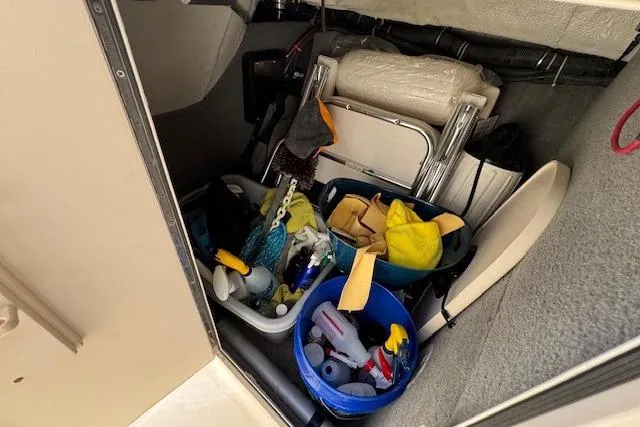 Slide: The Image of Storage compartment in 2021 Grady-White Freedom 307 boat with cleaning supplies and equipment. - 22