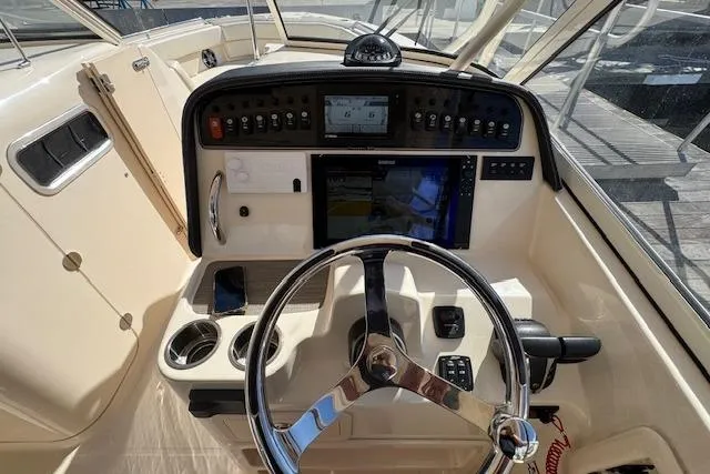 Slide: The Image of 2021 Grady-White Freedom 307 boat dashboard with steering wheel and navigation controls. - 26