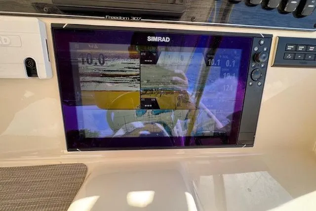 Slide: The Image of Simrad display on 2021 Grady-White Freedom 307 boat dashboard showing navigation data. - 29