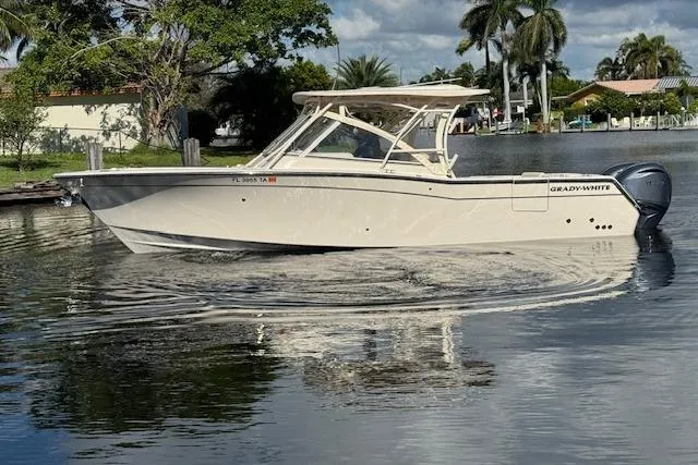 Slide: The Image of 2021 Grady-White Freedom 307 boat cruising on a calm waterway, surrounded by lush greenery. - 3