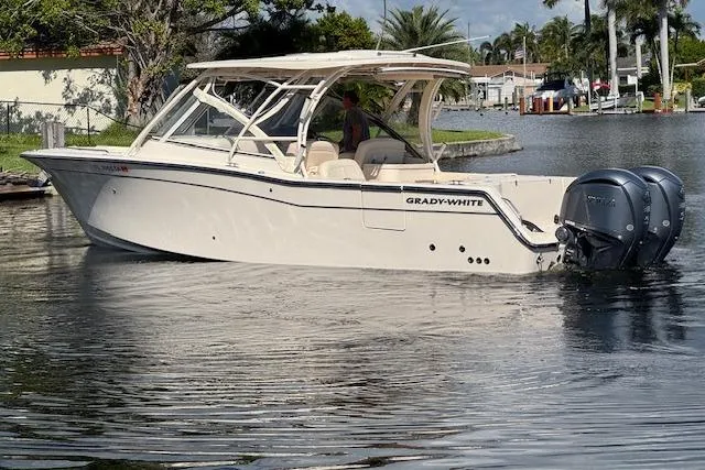 Slide: The Image of 2021 Grady-White Freedom 307 boat on calm water, featuring dual outboard engines. - 4