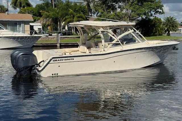 Slide: The Image of 2021 Grady-White Freedom 307 boat on calm water, surrounded by lush greenery. - 8
