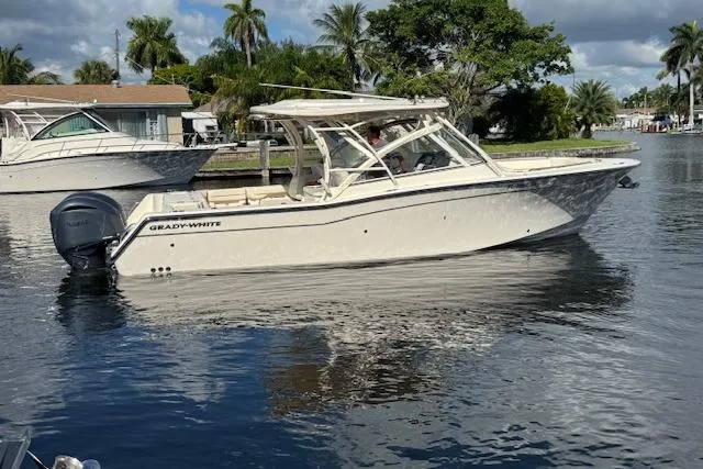 Slide: The Image of 2021 Grady-White Freedom 307 boat on calm water, surrounded by lush greenery. - 9