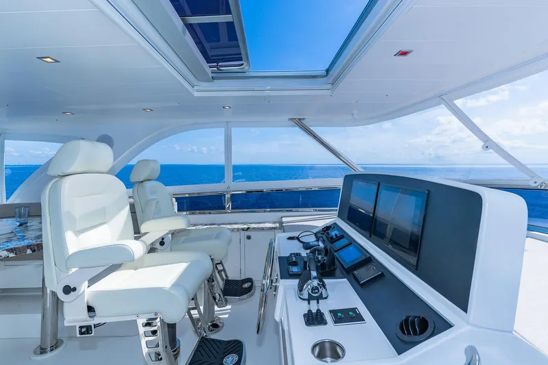 Slide: The Image of Luxurious Regency P65 yacht helm with ocean view, featuring modern controls and plush seating. - 19