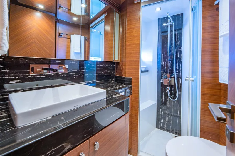 Slide: The Image of Luxurious bathroom in 2019 Regency P65 yacht with modern fixtures and elegant wood paneling. - 43