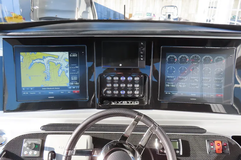 Slide: The Image of Dashboard of a 2017 Mystic M4200 boat with navigation and control screens. - 14