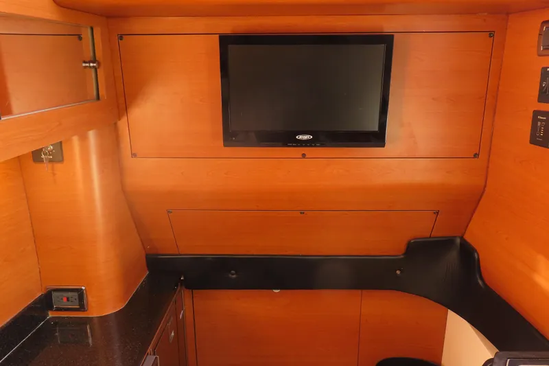 Slide: The Image of Interior of 2017 Mystic M4200 boat with wood paneling and mounted TV. - 25